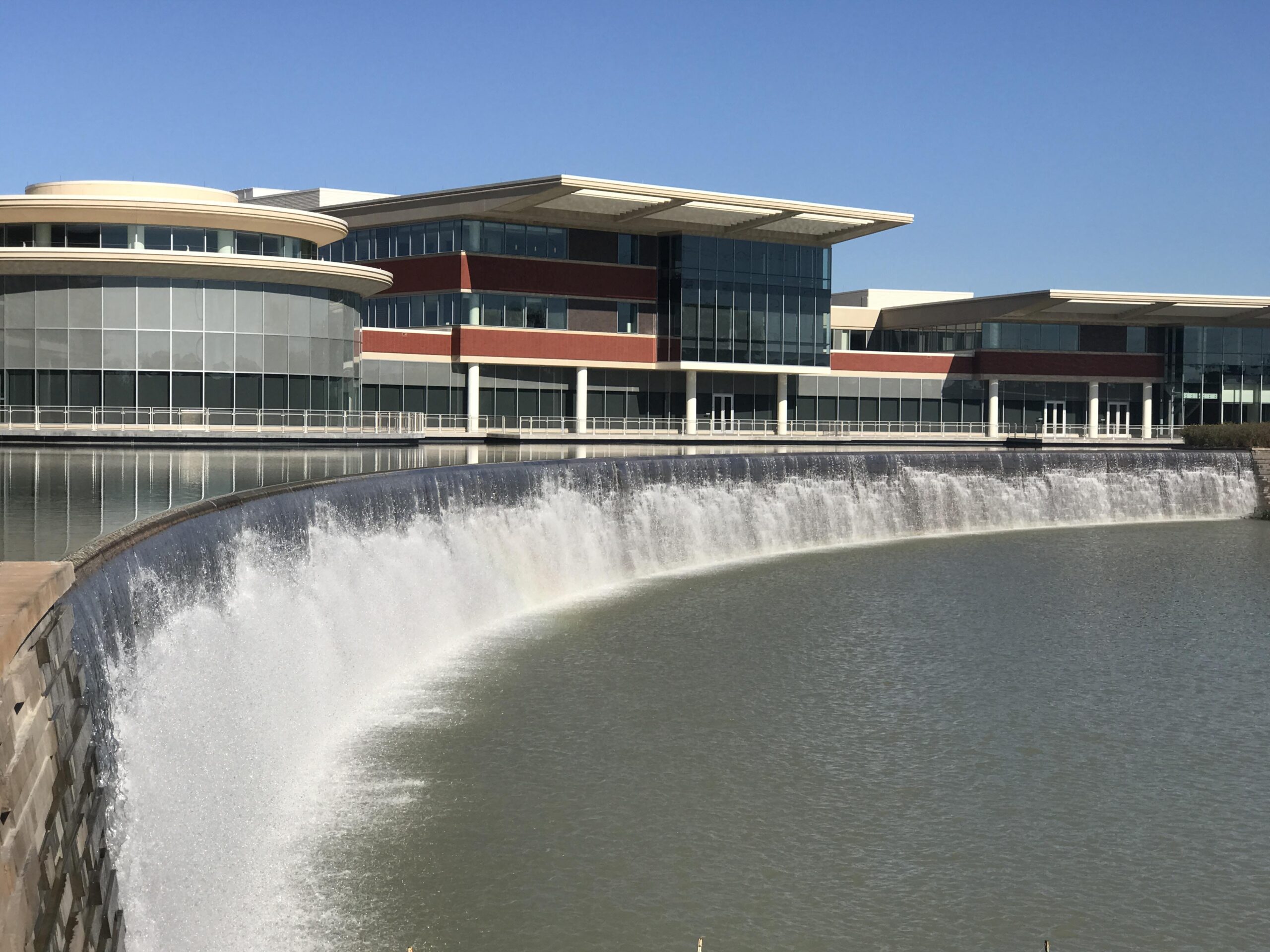 Nw hospital 3 An expansive water feature outside of a large, modern hospital featuring waterfall fountains and a large pond.