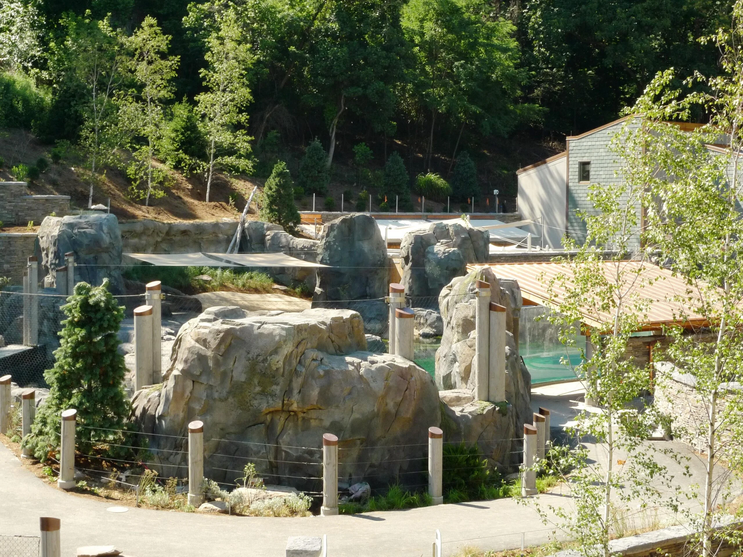 National zoossl1 An expansive outdoor habitat at the National Zoo featuring a variety of artificial rockwork - boulders and cliffs, landscaping, and more. The habitat also has a large wading pool and is surrounded by natural landscaping.