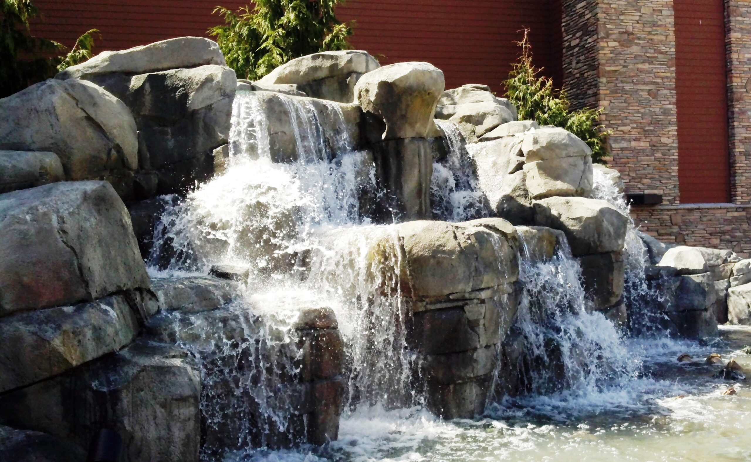 Silverreef casino A fast flowing water fall spills over giant stacked rocks and boulders, into a wading pool.